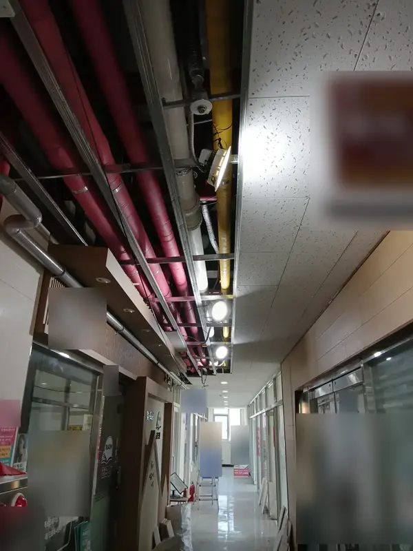천장 위로 배관이 드러난 상가 복도